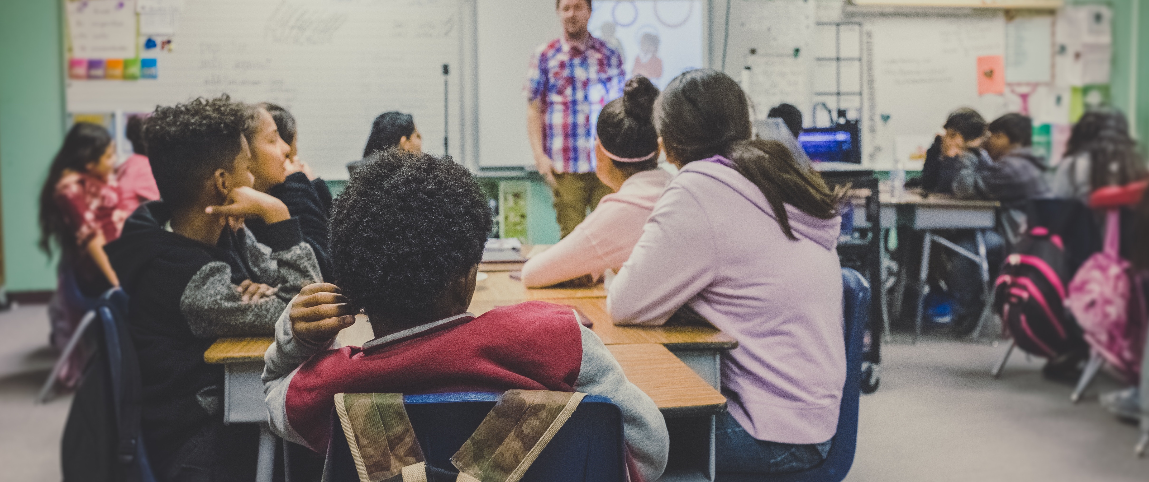 Students in a classroom listening to teacher